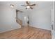 Open living room featuring wood laminate flooring, a ceiling fan, and a staircase at 396 S 166Th Dr, Goodyear, AZ 85338
