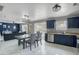 An eat-in kitchen with a dining area featuring a wooden table and sleek, royal-blue cabinets at 40161 N Westray Way, San Tan Valley, AZ 85140