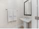 Clean and modern powder room featuring a pedestal sink, stylish mirror, and fresh white towels at 42046 N Golden Trl, San Tan Valley, AZ 85140