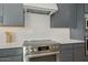 Close-up of the kitchen showcasing stainless steel range, white subway tile backsplash, and gray cabinets at 42046 N Golden Trl, San Tan Valley, AZ 85140