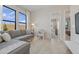 Bright living room with a gray sectional, clear coffee table, and large windows at 42046 N Golden Trl, San Tan Valley, AZ 85140