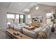 Bright and airy living room with a large sectional sofa, TV, stylish decor, and sliding glass doors to the patio at 42046 N Golden Trl, San Tan Valley, AZ 85140