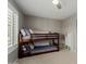 Inviting bedroom showcasing a wooden bunk bed, plush pillows, and a window with open shutters at 4842 W Christine Cir, Glendale, AZ 85308