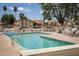 Community pool area with lounge chairs and tables, surrounded by mature trees and well maintained landscaping at 542 S Higley Rd # 52, Mesa, AZ 85206