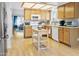 Well-lit kitchen featuring wooden cabinetry, an island, white appliances, and an adjacent living area at 542 S Higley Rd # 52, Mesa, AZ 85206