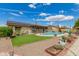Landscaped backyard with fenced in pool, artificial turf, desert landscaping and solar panels at 5537 W Boca Raton Rd, Glendale, AZ 85306