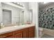 Bathroom with single sink vanity, a large mirror, and separate toilet and shower area at 5537 W Boca Raton Rd, Glendale, AZ 85306