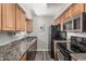 Functional kitchen with granite countertops, black appliances, and sufficient cabinet storage at 5877 N Granite Reef Rd # 2240, Scottsdale, AZ 85250