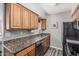 Well-appointed kitchen featuring granite countertops, wood cabinets, and updated appliances at 5877 N Granite Reef Rd # 2240, Scottsdale, AZ 85250