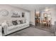 Cozy living room flows into dining area, featuring a gray sofa, and modern flooring at 5877 N Granite Reef Rd # 2240, Scottsdale, AZ 85250