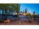 Backyard featuring desert landscaping, exterior lighting, and Southwestern architecture at 612 N Signal Butte Rd, Mesa, AZ 85207