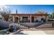 Backyard with steps leading to a charming home, showcasing desert landscaping and a vibrant red door at 612 N Signal Butte Rd, Mesa, AZ 85207