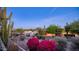 Backyard view at twilight with desert plants and pink bougainvillea bushes, and views of mountains and landscape at 612 N Signal Butte Rd, Mesa, AZ 85207