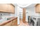 Bright laundry room features terracotta tile floors, wooden cabinets and a new washer and dryer at 612 N Signal Butte Rd, Mesa, AZ 85207