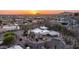 Panoramic sunset aerial view of a desert home and vibrant community nestled near majestic mountains at 612 N Signal Butte Rd, Mesa, AZ 85207