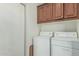 Bright laundry room features a washer, dryer, and upper cabinets for storage space at 6331 S Cypress Point Dr, Chandler, AZ 85249