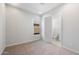 Bright bedroom with neutral carpet, light walls, and a door leading to a clean, tiled bathroom at 674 W Rock Needle Trl, Apache Junction, AZ 85120