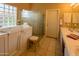 Bright bathroom features a walk-in bathtub, a glass block window, and a vanity with double sinks at 6855 E Amber Sun Dr, Scottsdale, AZ 85266