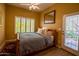 A serene bedroom with wood floors, a ceiling fan, and a window with white shutters at 6855 E Amber Sun Dr, Scottsdale, AZ 85266