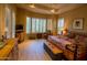 Serene bedroom with wooden floors, plantation shutters, and a decorative chest, offering a relaxing retreat at 6855 E Amber Sun Dr, Scottsdale, AZ 85266