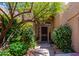 Home's covered front entrance with security door surrounded by lush desert landscaping at 6855 E Amber Sun Dr, Scottsdale, AZ 85266