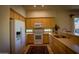 Well-lit kitchen with light wood cabinets, modern white appliances, and tile flooring, offering a clean space at 6855 E Amber Sun Dr, Scottsdale, AZ 85266