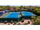 Aerial view of well-maintained tennis courts surrounded by lush landscaping at 6855 E Amber Sun Dr, Scottsdale, AZ 85266