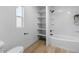Neat bathroom featuring a tub/shower with built-in shelves and a bright window at 7836 E Juanita Ave, Mesa, AZ 85208