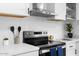 Close-up showcasing stainless steel range, hood and white countertop with neutral backsplash at 7836 E Juanita Ave, Mesa, AZ 85208