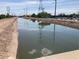 Picturesque water canal reflecting power lines, lush trees, and blue sky at 849 W Duke Dr, Tempe, AZ 85283