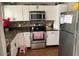 Well-lit kitchen featuring white cabinets, granite countertops, and stainless steel appliances at 849 W Duke Dr, Tempe, AZ 85283