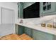 Bar area with custom green cabinetry, marble countertops, and decorative elements at 9736 E Turquoise Ave, Scottsdale, AZ 85258
