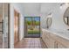 Bright bathroom with double vanity, large sliding glass door to backyard, and terra cotta flooring at 9736 E Turquoise Ave, Scottsdale, AZ 85258