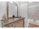 Elegant bathroom featuring a wooden vanity, large mirror, and soaking tub at 9736 E Turquoise Ave, Scottsdale, AZ 85258