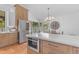 Kitchen showcasing stainless steel appliances, including a refrigerator and microwave, with a view to the dining area at 9736 E Turquoise Ave, Scottsdale, AZ 85258