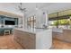 Open kitchen with a large island, custom cabinets, and a view of the backyard through a large window at 9736 E Turquoise Ave, Scottsdale, AZ 85258