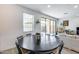 Bright dining area with a dark wood table, sliding glass doors to the backyard, and an open floor plan at 9916 E Texas Ave, Mesa, AZ 85212