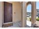 Inviting front porch featuring a dark-stained front door and decorative stone columns at 9916 E Texas Ave, Mesa, AZ 85212