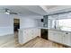 Bright kitchen with white cabinets, modern appliances, wood-look floors, and a breakfast bar at 10016 N 39Th Dr, Phoenix, AZ 85051
