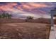 This backyard features a block wall and desert landscaping under a gorgeous sunset sky at 10831 E Azalea Ave, Mesa, AZ 85208