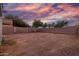 This backyard features a block wall and desert landscaping under a gorgeous sunset sky at 10831 E Azalea Ave, Mesa, AZ 85208