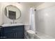 A modern bathroom featuring white herringbone tiles in shower and blue vanity with a round mirror at 10831 E Azalea Ave, Mesa, AZ 85208