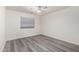 This bright bedroom features wood-look floors, a ceiling fan, and a window with blinds at 10831 E Azalea Ave, Mesa, AZ 85208