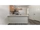 Bright kitchen featuring a breakfast bar with modern sink, light wood cabinets, and stylish backsplash at 10831 E Azalea Ave, Mesa, AZ 85208