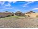 Large, fully fenced backyard features a grassy area and gravel section, creating versatile outdoor space at 12605 W Dreyfus Dr, El Mirage, AZ 85335