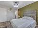 Comfortable bedroom with unique green accent wall and carpet flooring at 12605 W Dreyfus Dr, El Mirage, AZ 85335