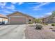 Exterior of tan house with a two car garage and desert landscaping at 12605 W Dreyfus Dr, El Mirage, AZ 85335