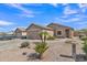 Exterior view of a tan home with desert landscaping, two car garage, and walkway to the front door at 12605 W Dreyfus Dr, El Mirage, AZ 85335