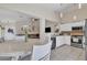 Dining area with a white table set, a view into a living room, and a kitchen with stainless steel appliances at 12605 W Dreyfus Dr, El Mirage, AZ 85335