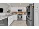 Kitchen with white cabinets, stainless steel appliances, and tile backsplash at 12605 W Dreyfus Dr, El Mirage, AZ 85335